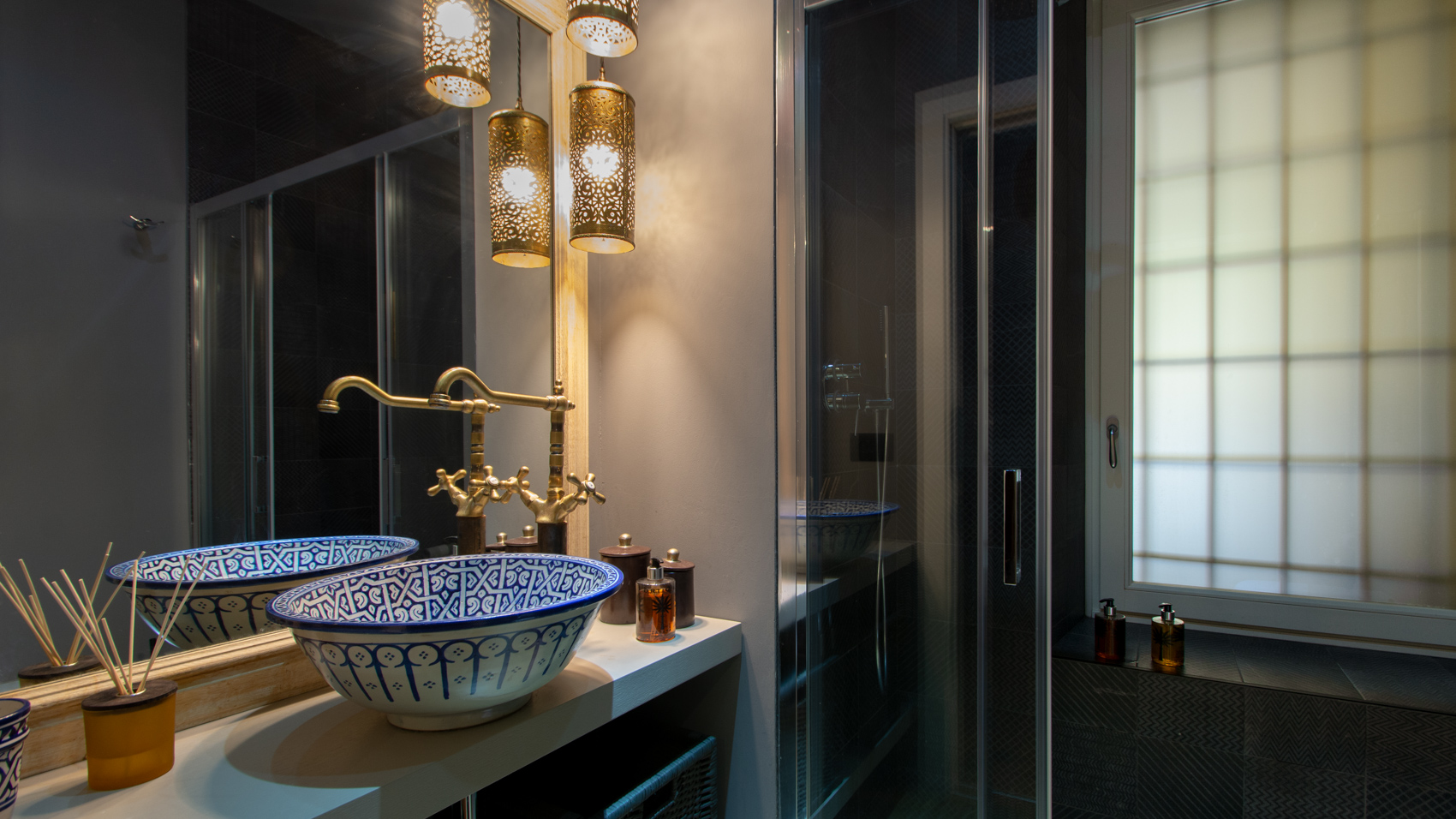 Bathroom two with decorated basin, brass fittings and mirror