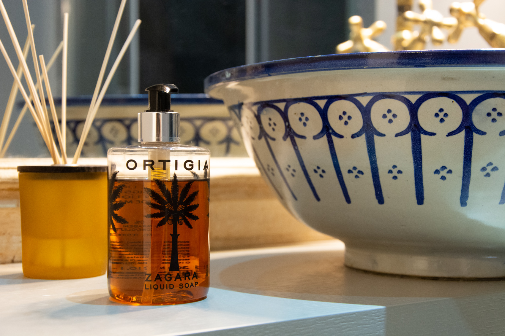 Ortigia diffuser beside a hand-painted blue ceramic bowl