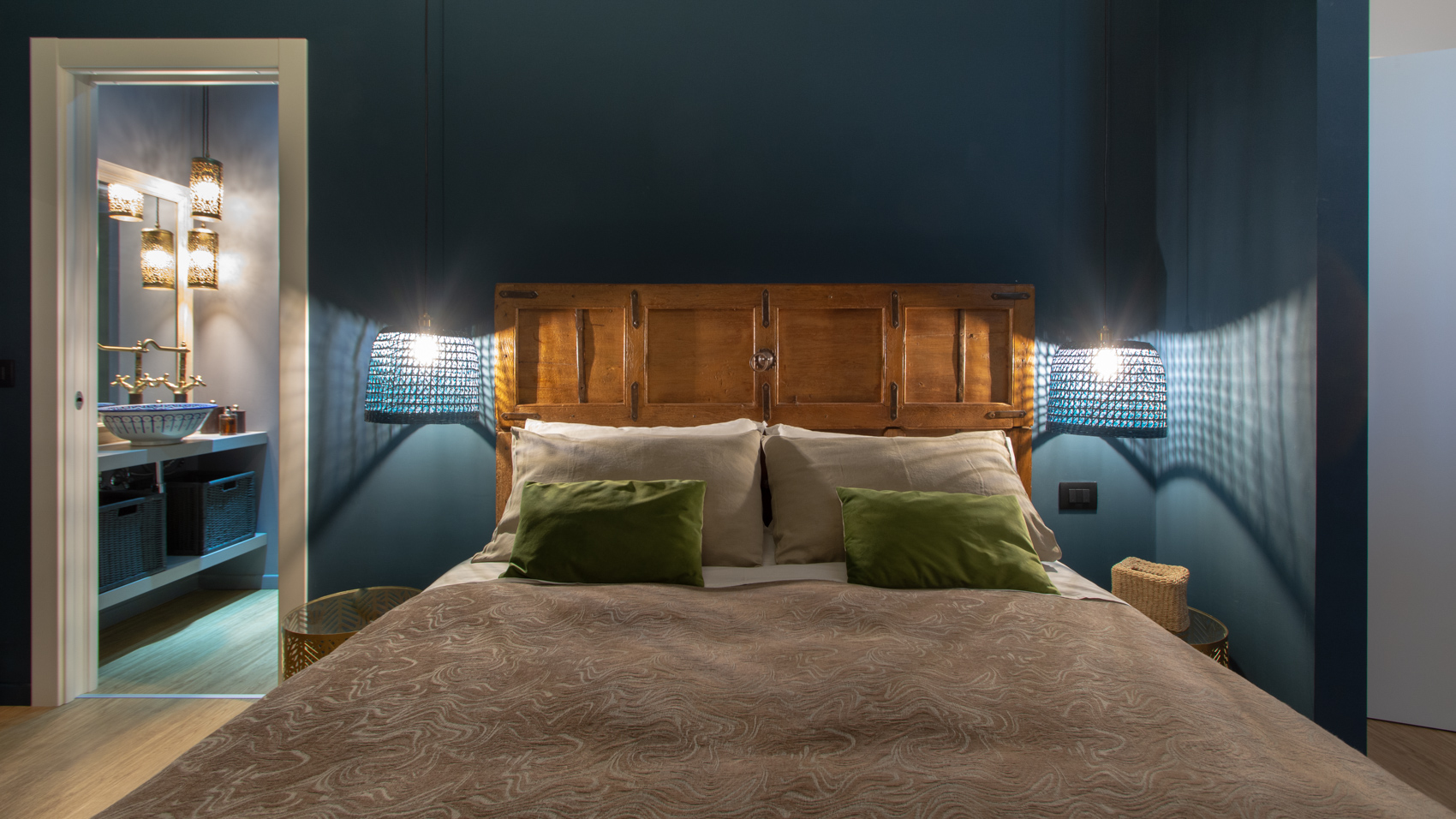 Bedroom one with green cushions and ensuite bathroom doorway