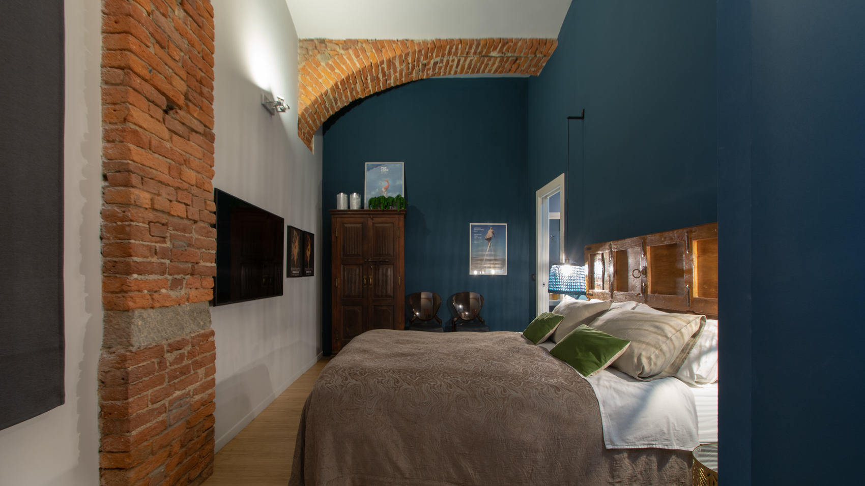 Bedroom two with exposed brick column and blue walls