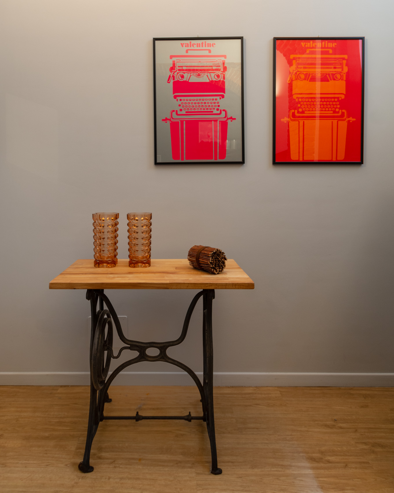 Console table with vintage sewing base and pink framed prints