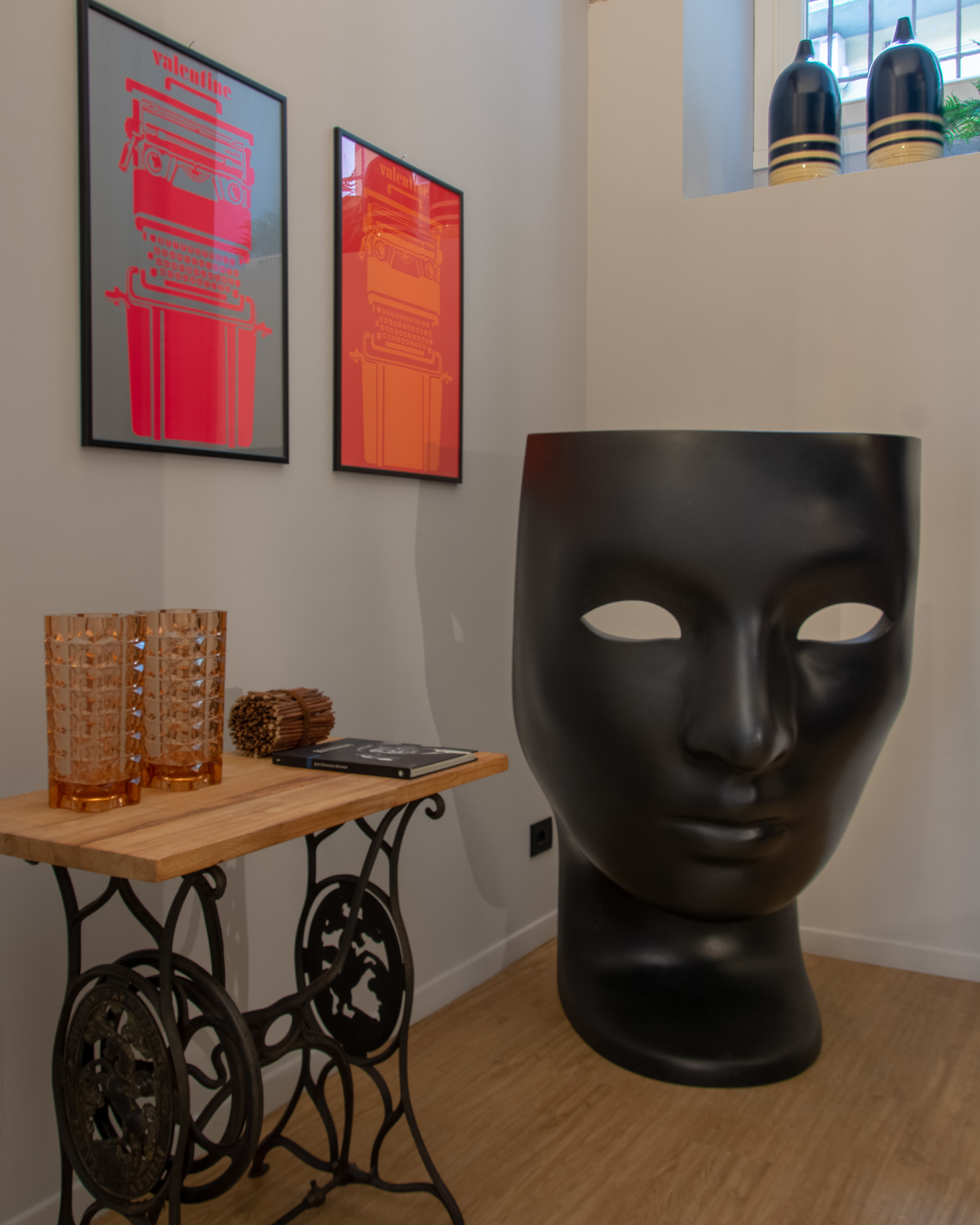 Entrance decor with console, red prints and black face sculpture