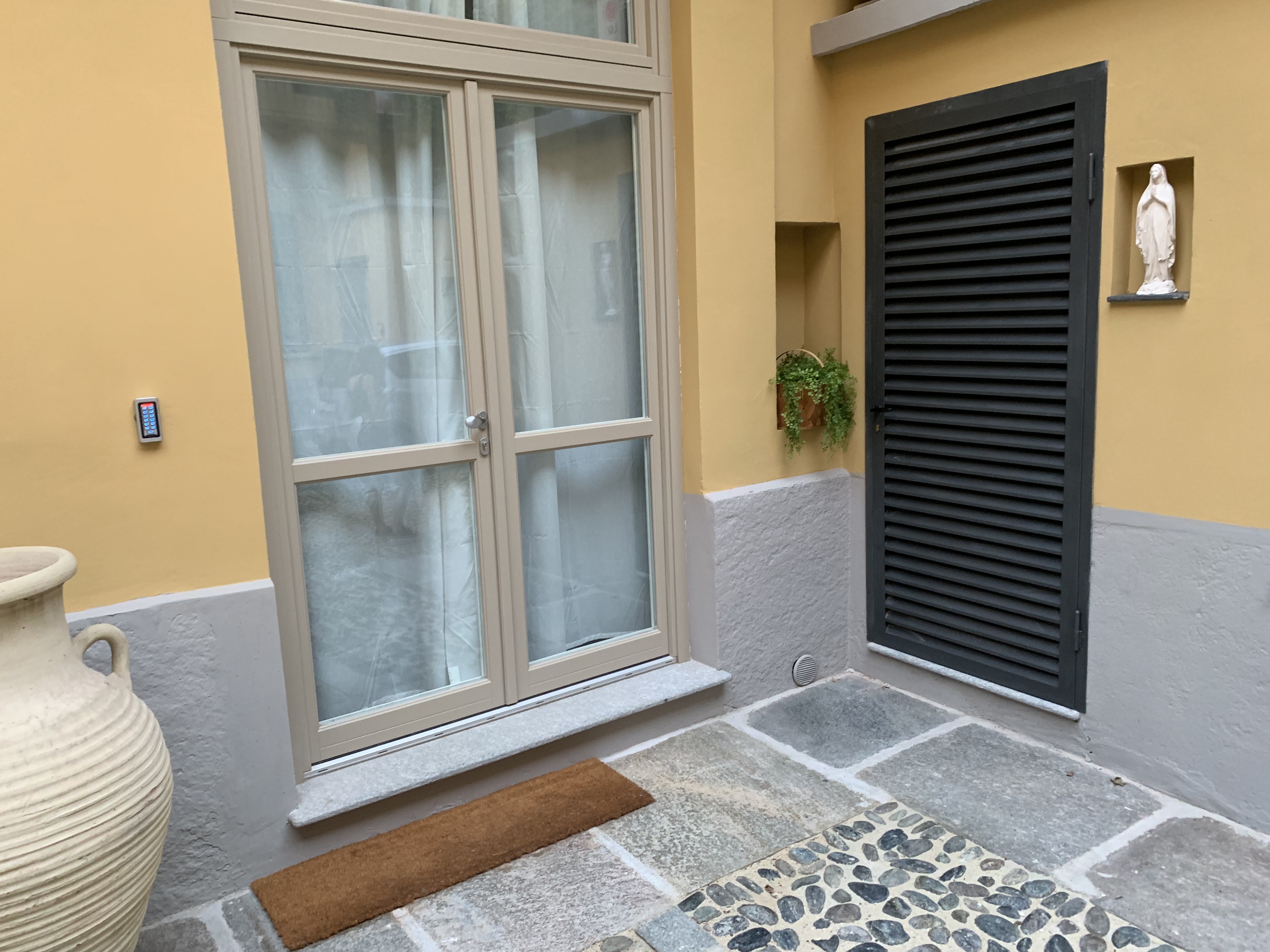Cobblestone courtyard and windows of the 15th-century building, Quadrilatero Romano
