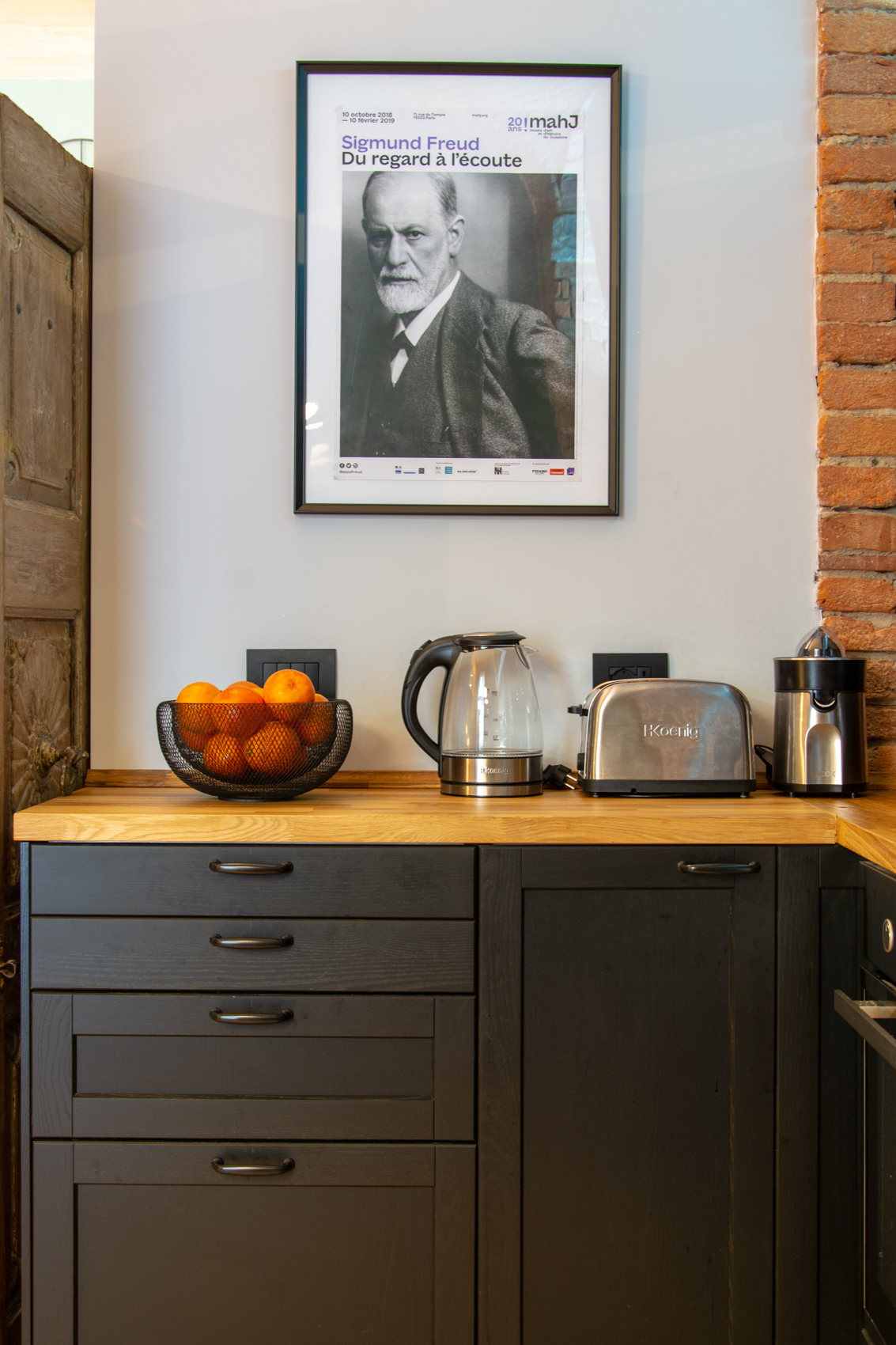 Kitchen worktop with framed portrait and bowl of oranges