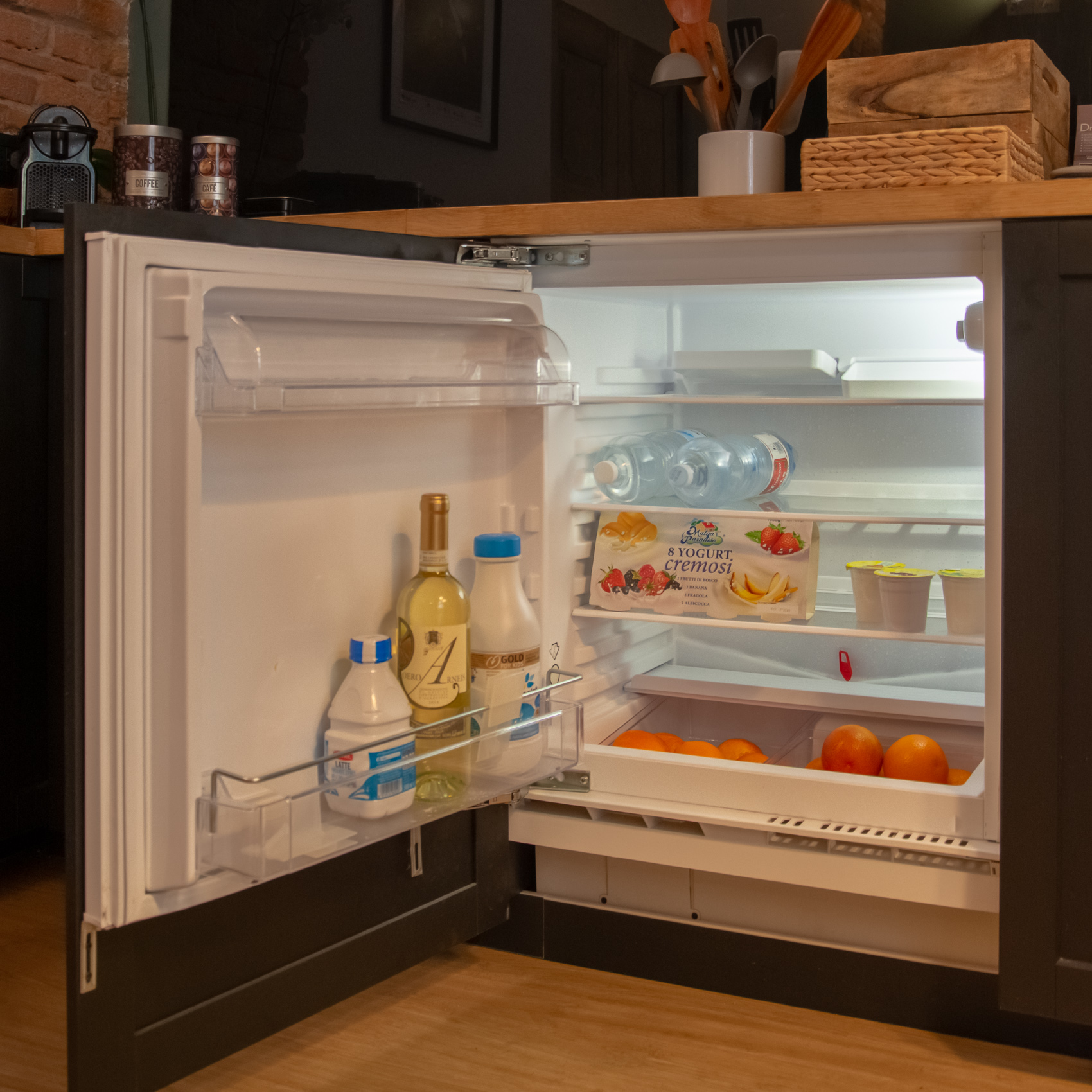 Stocked under-counter refrigerator in the kitchen